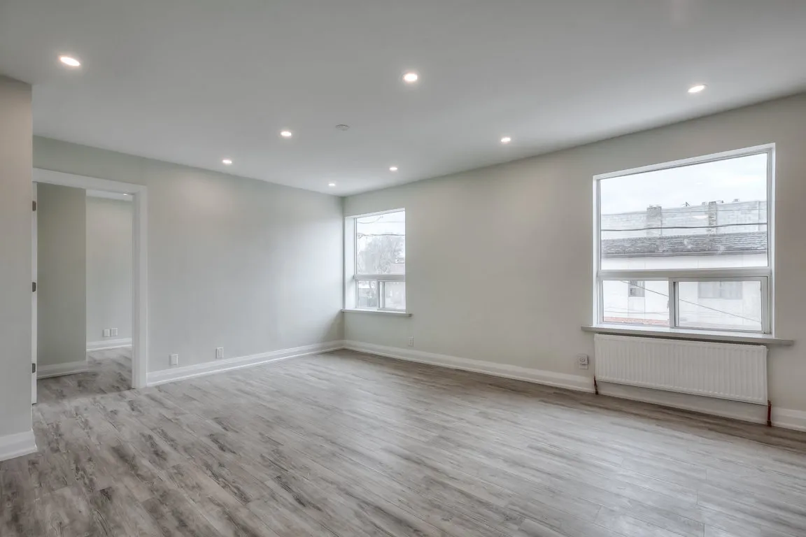 white room with hardwood floor and bright window