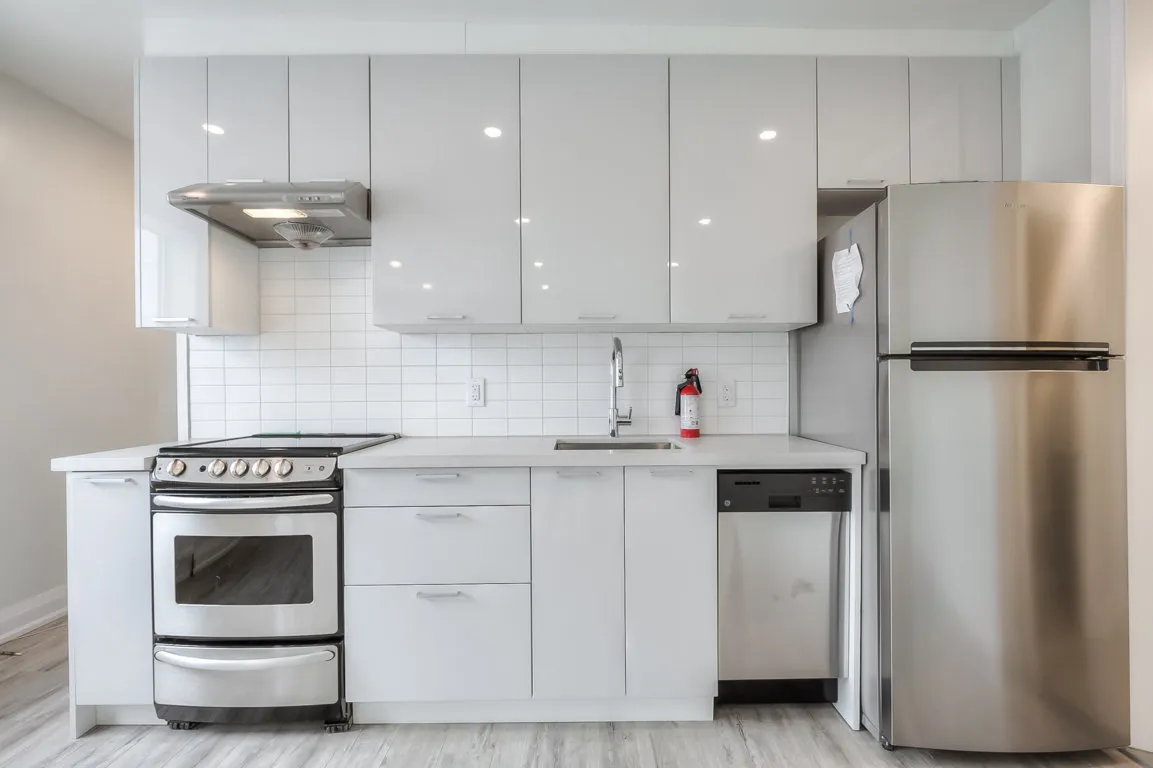 open concept kitchen with white cupboards and stainless steal appliances