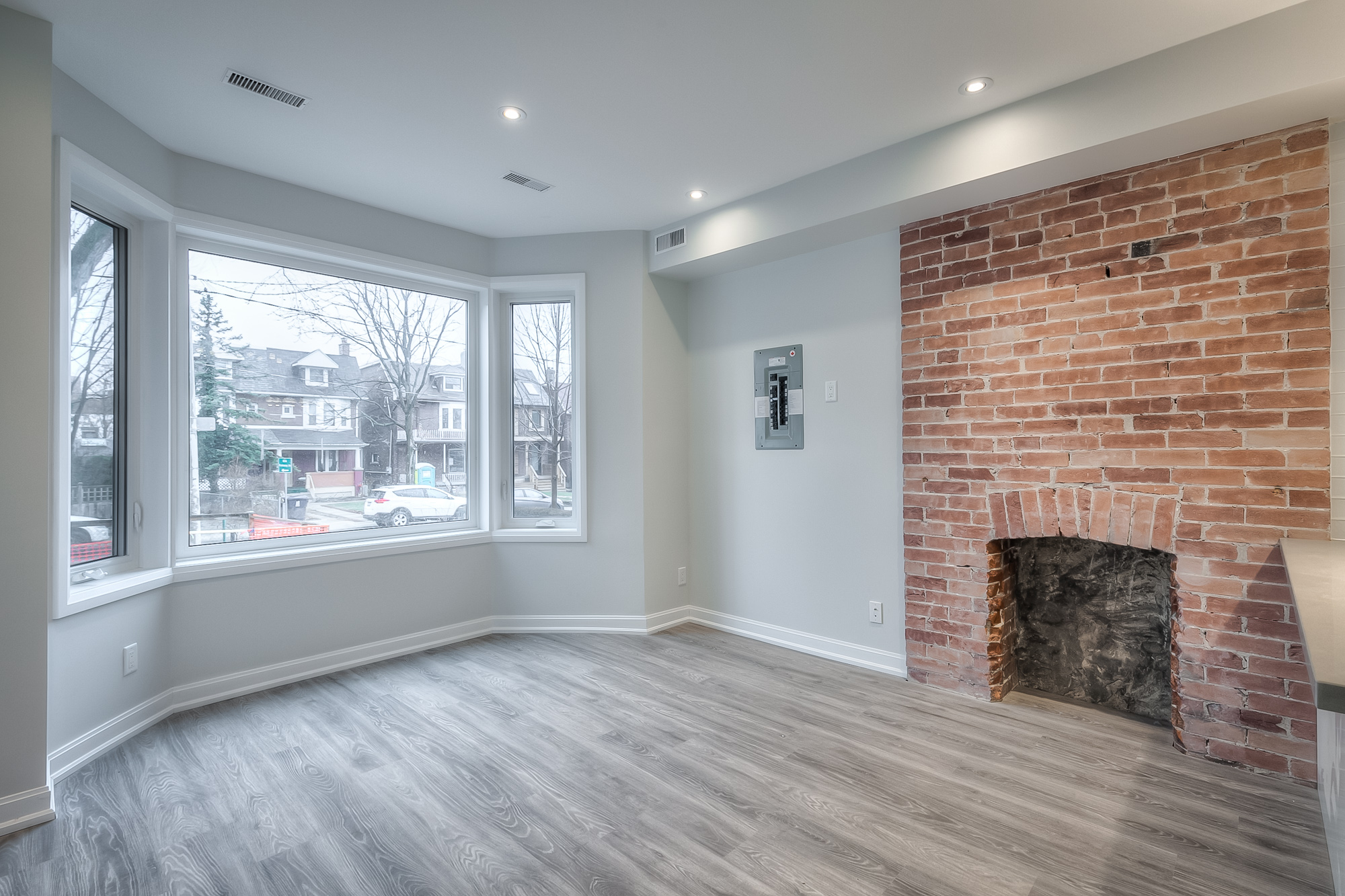 living room with exposed brick wall and hardwood floors