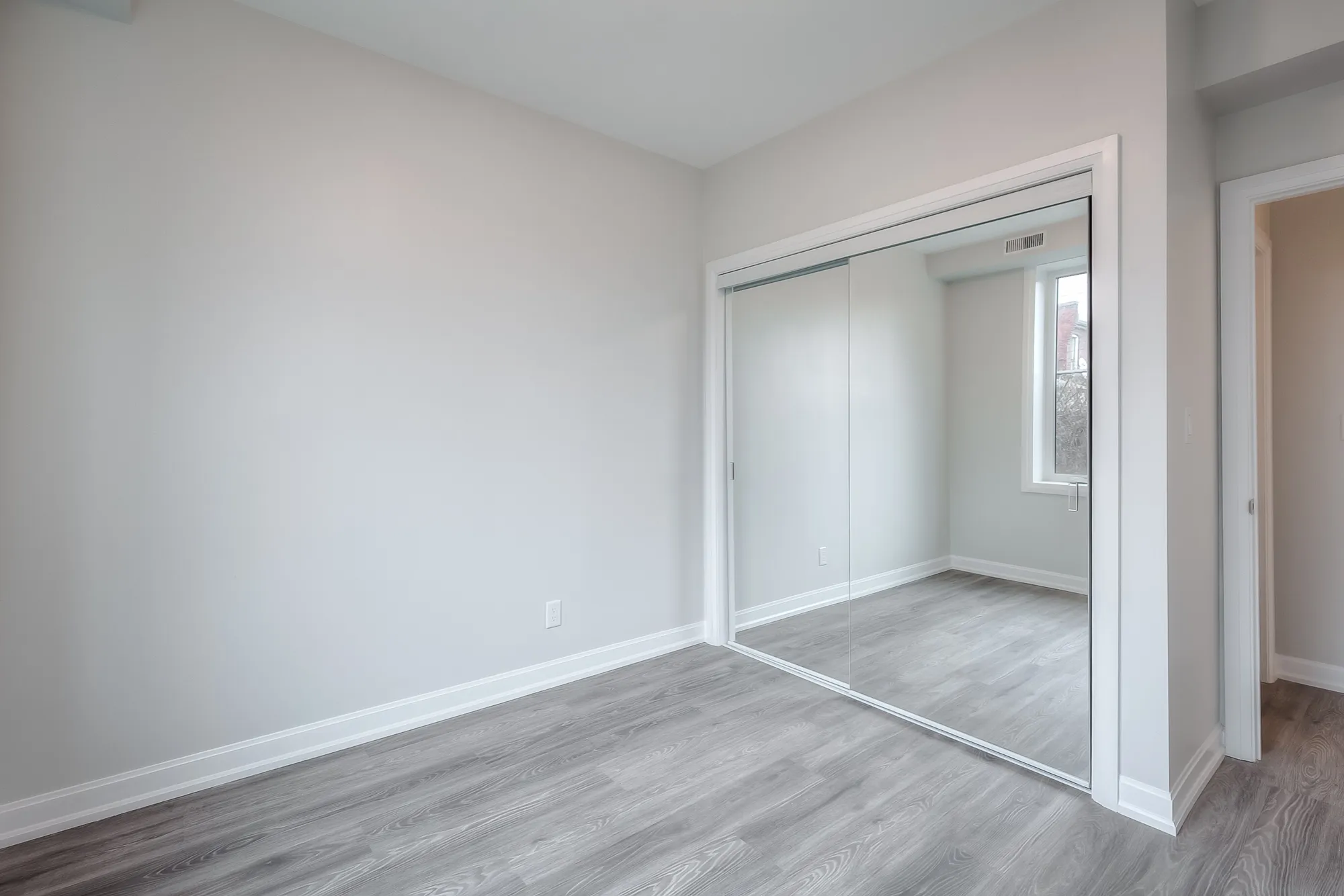 bedroom with hardwood floors and mirrored closets