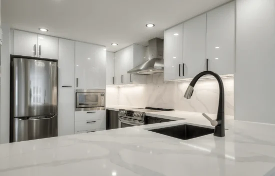 A kitchen with white cabinets and a sink