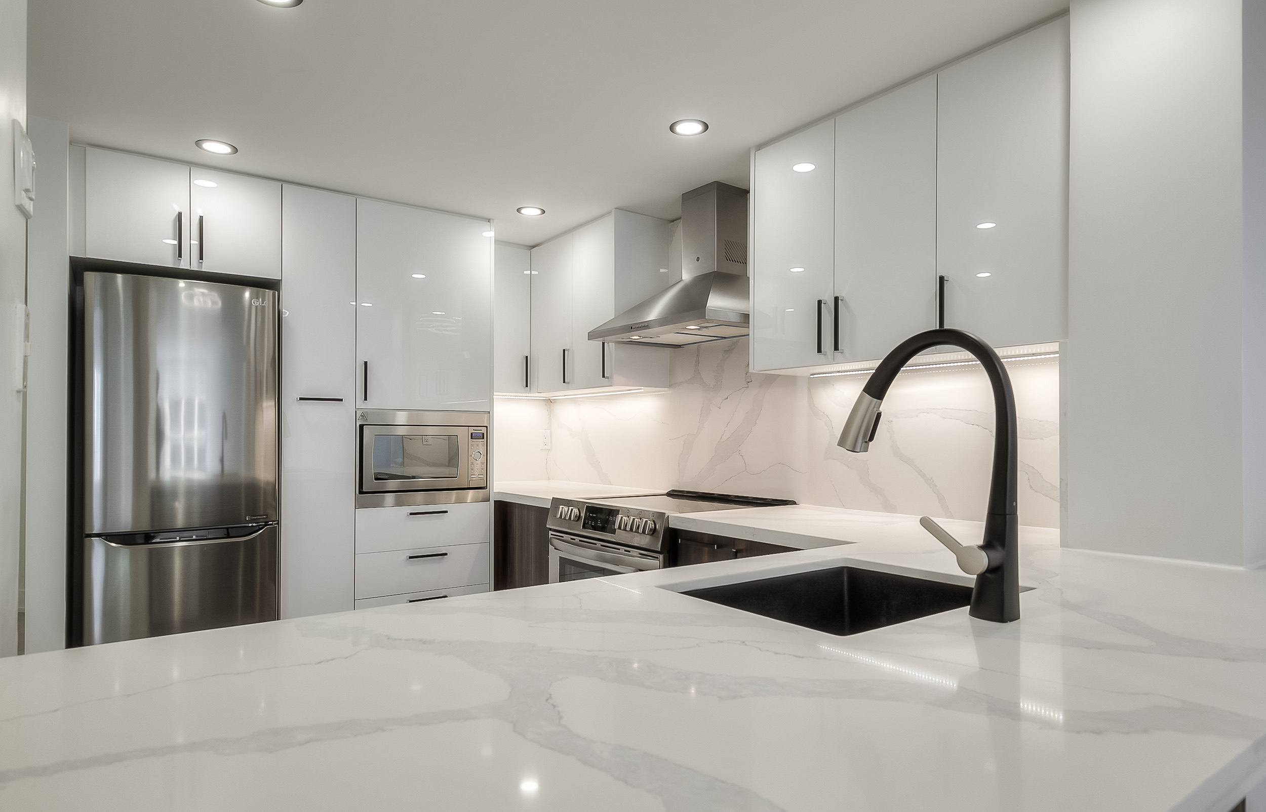 A kitchen with white cabinets and a sink