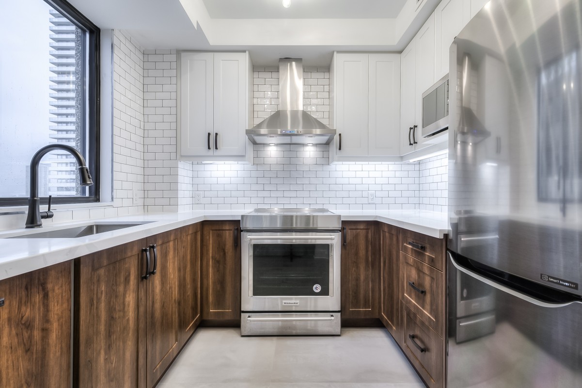 A kitchen with white cabinets and stainless steel stove
