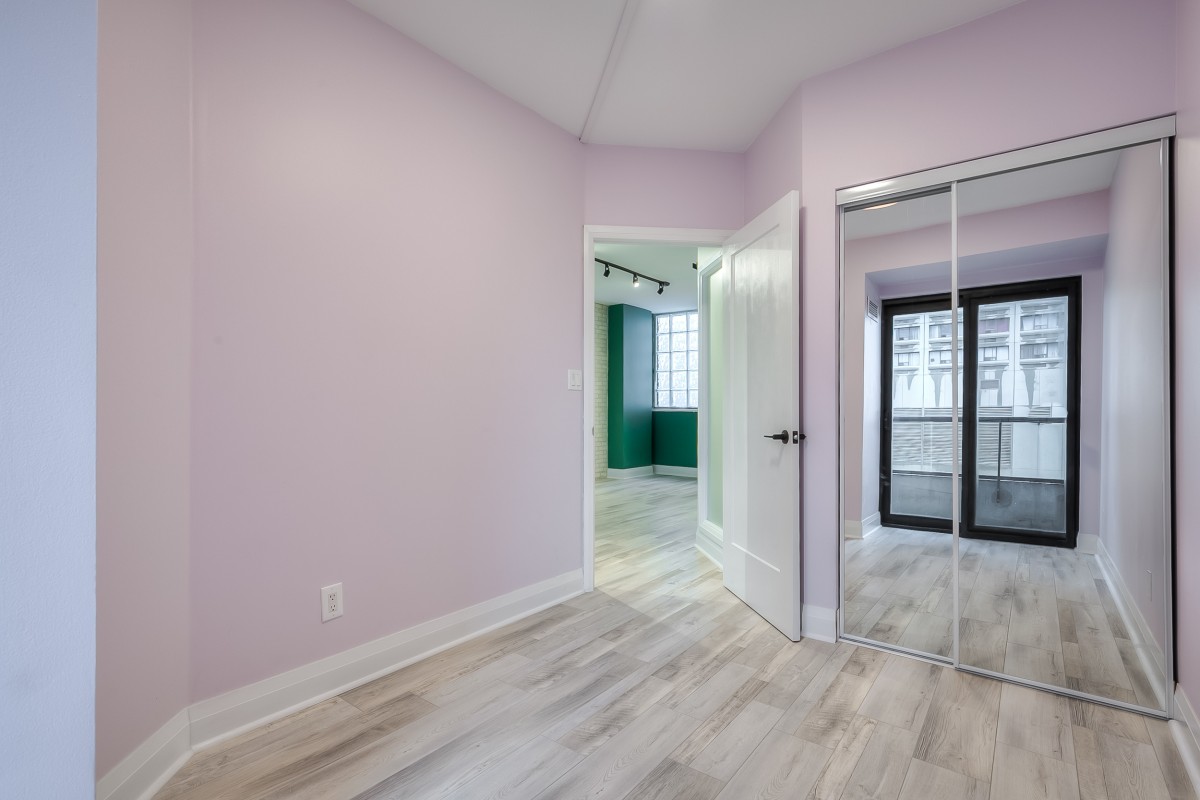 A room with a pink wall and a wood floor