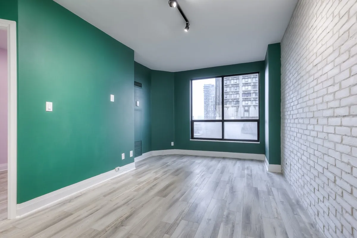 A room with green walls and a white brick wall