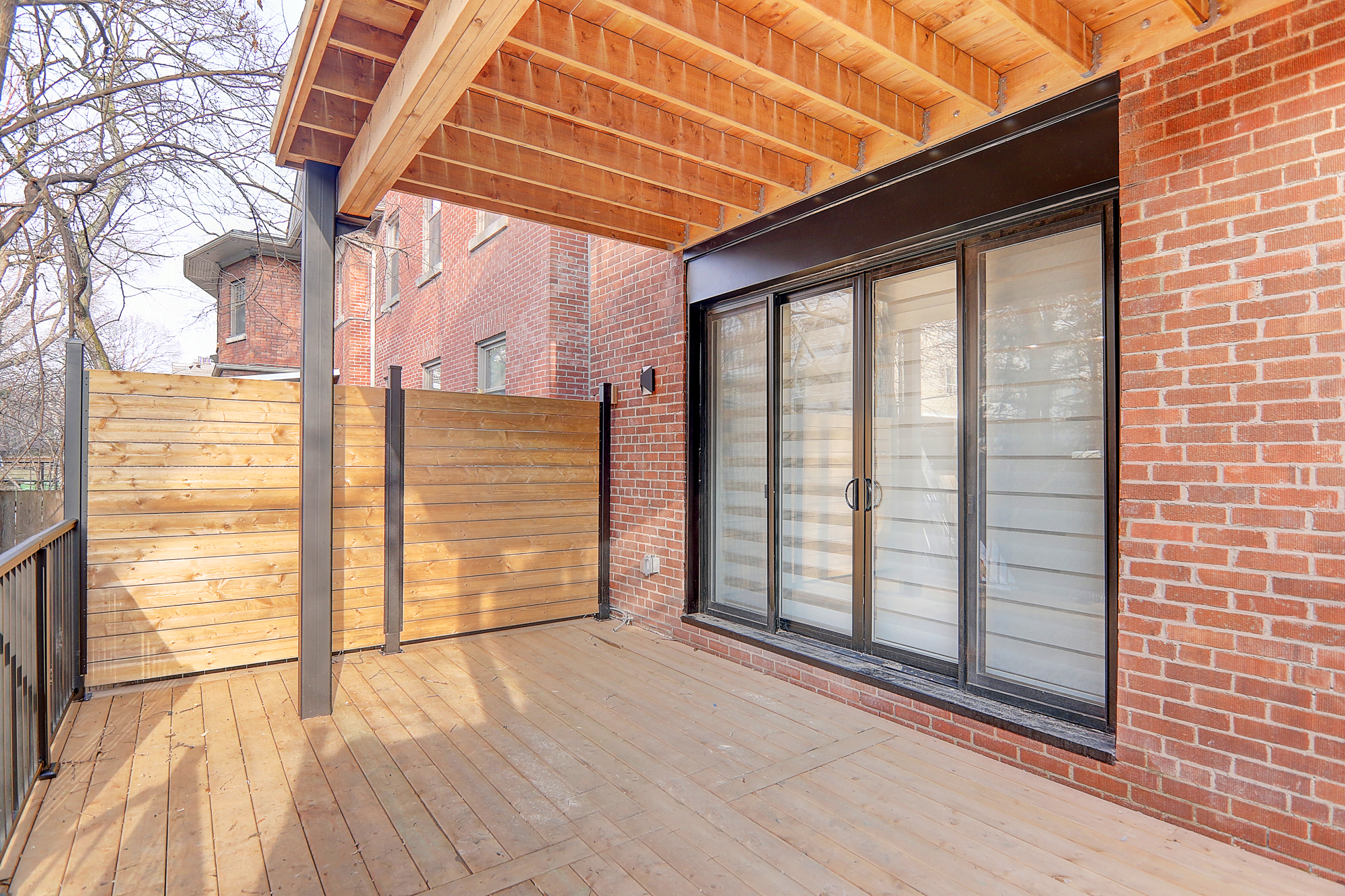 A patio with a wood deck and a wooden fence