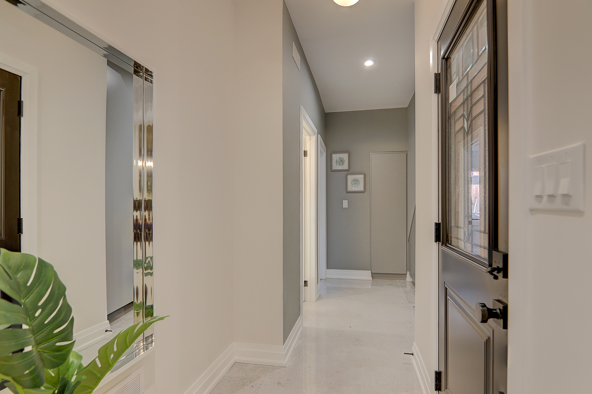 A hallway with white walls and a mirror