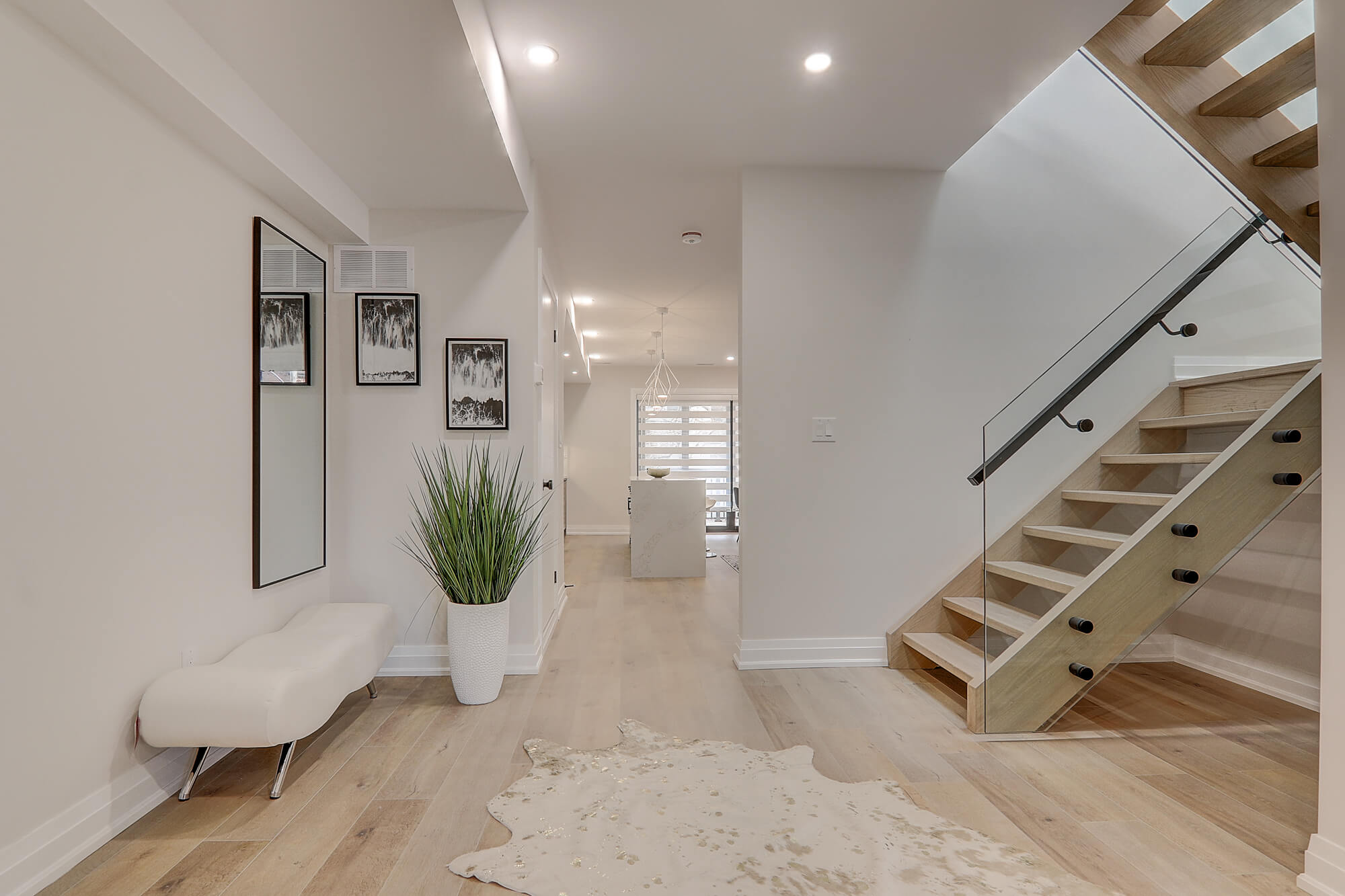 A hallway with stairs and a white bench
