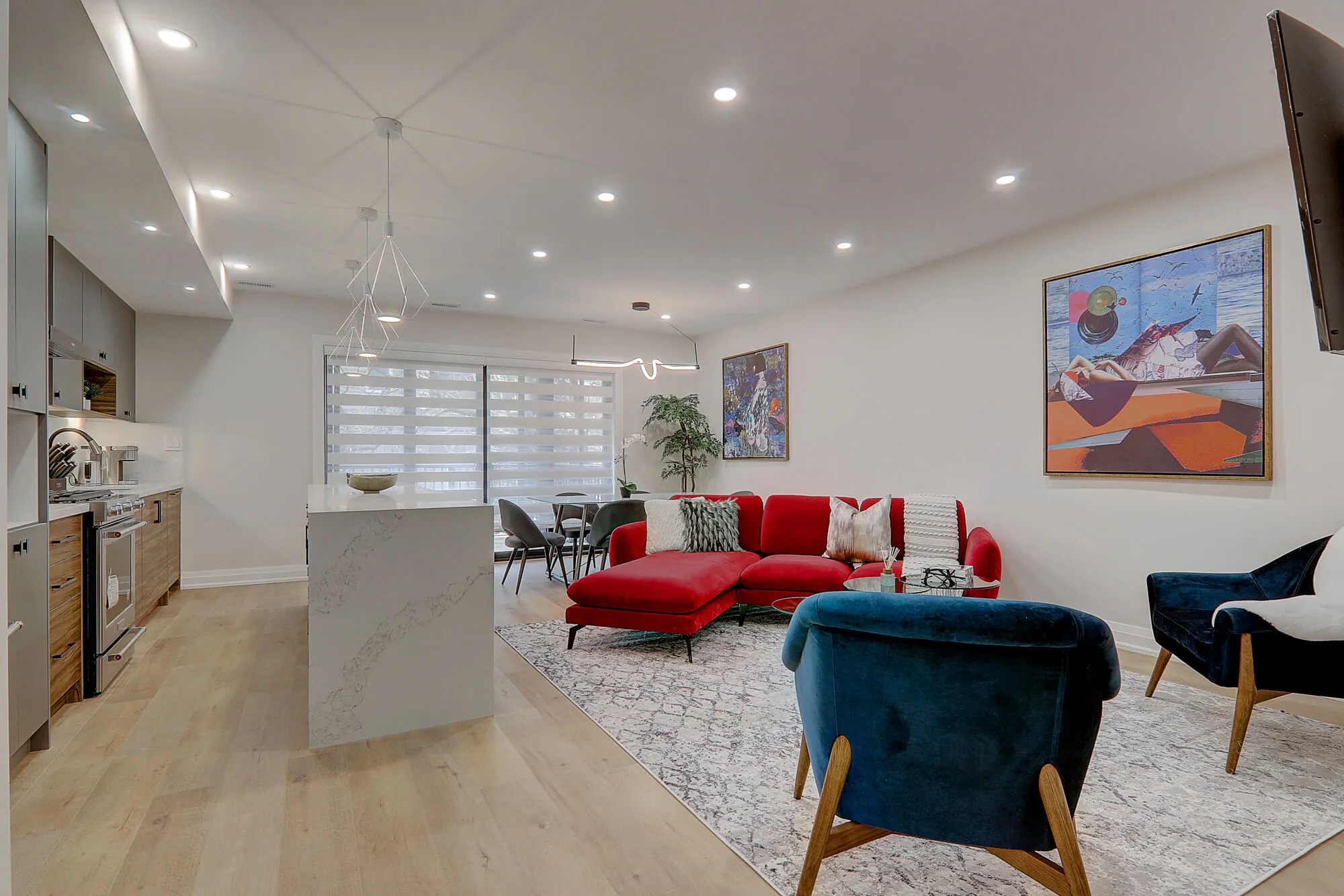 A living room with a red couch and a blue chair