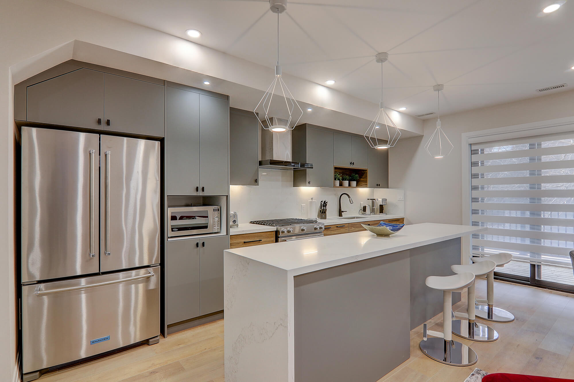 A kitchen with a white island and stainless steel appliances