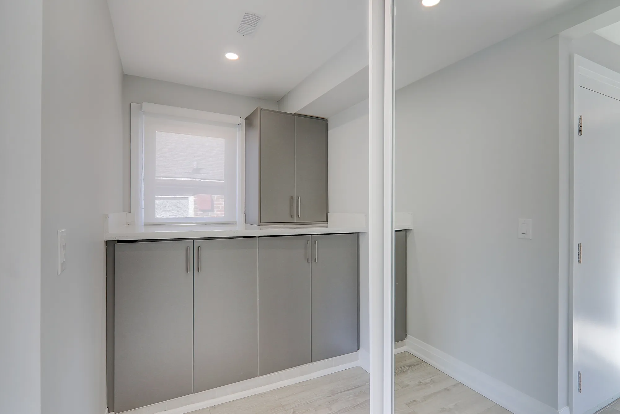 A room with a mirror and cabinets