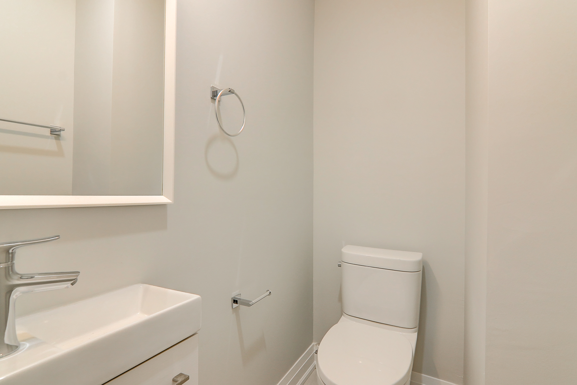 A white bathroom with a toilet and sink