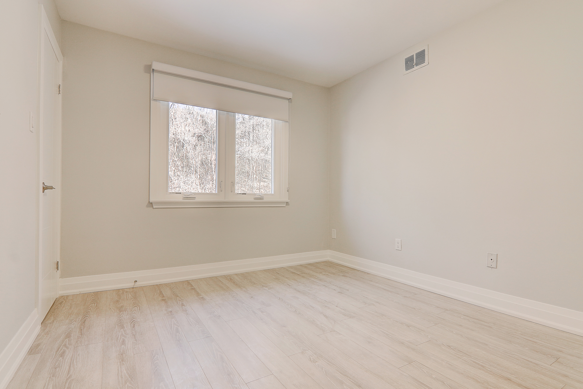 A room with a window and hardwood floor