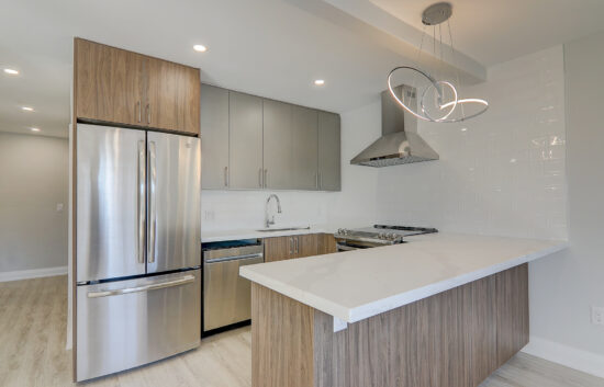 A kitchen with a white counter top and stainless steel appliances
