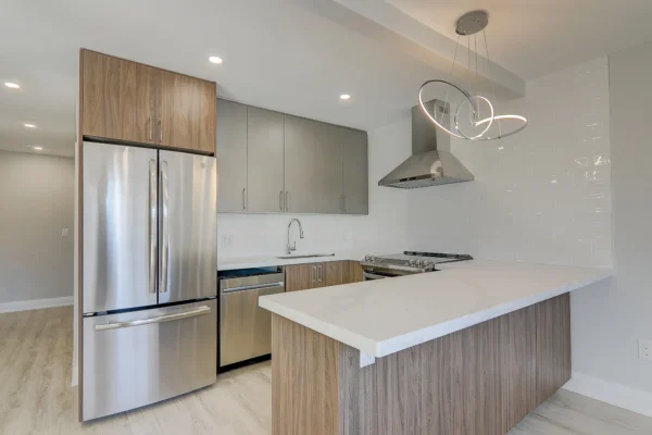 A kitchen with a white counter top and stainless steel appliances