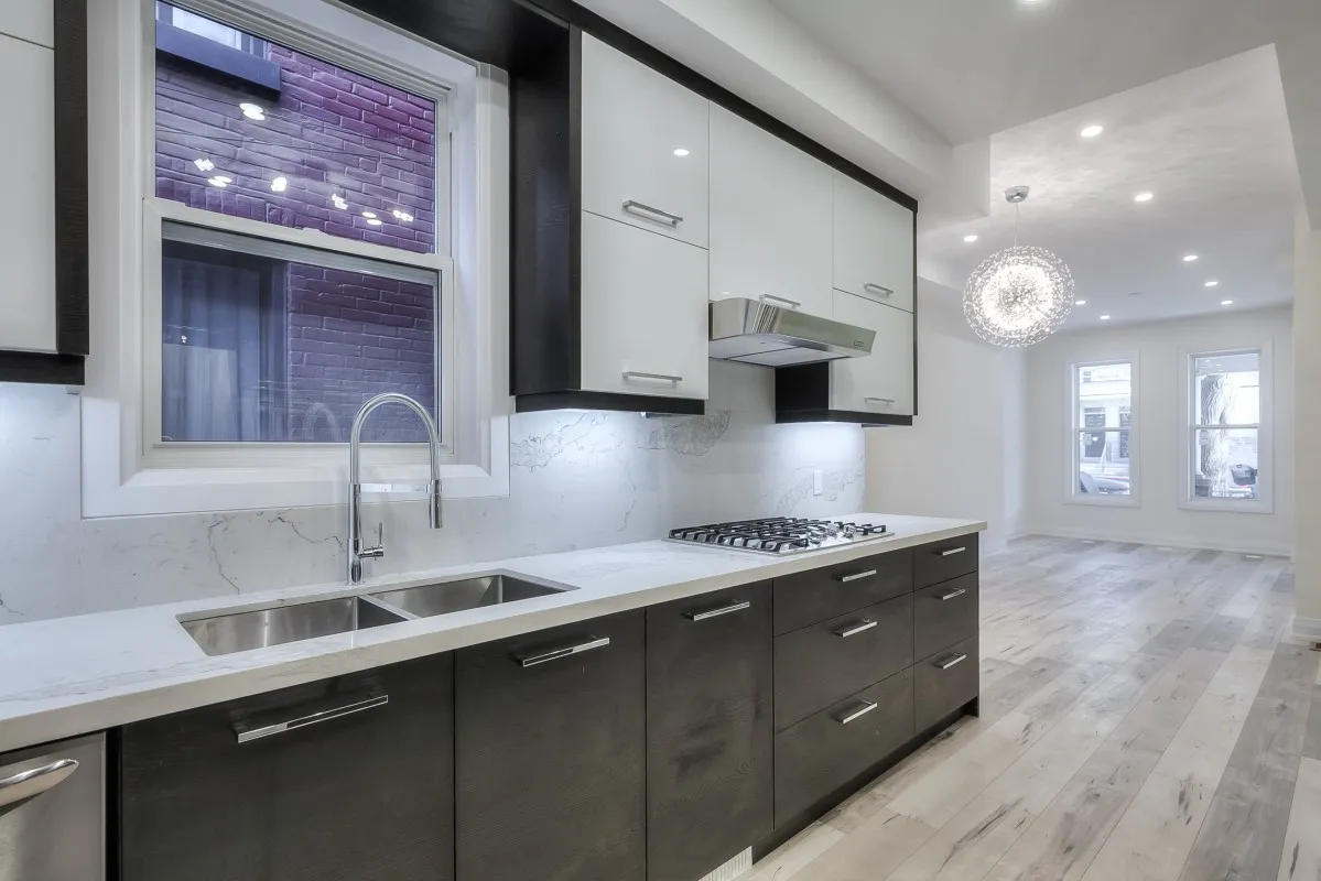 A kitchen with white cabinets and black cabinets