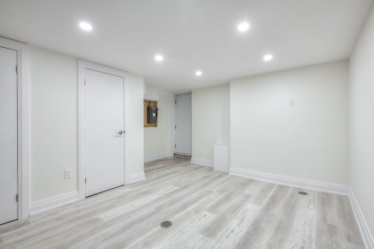 A room with a white door and wood floors