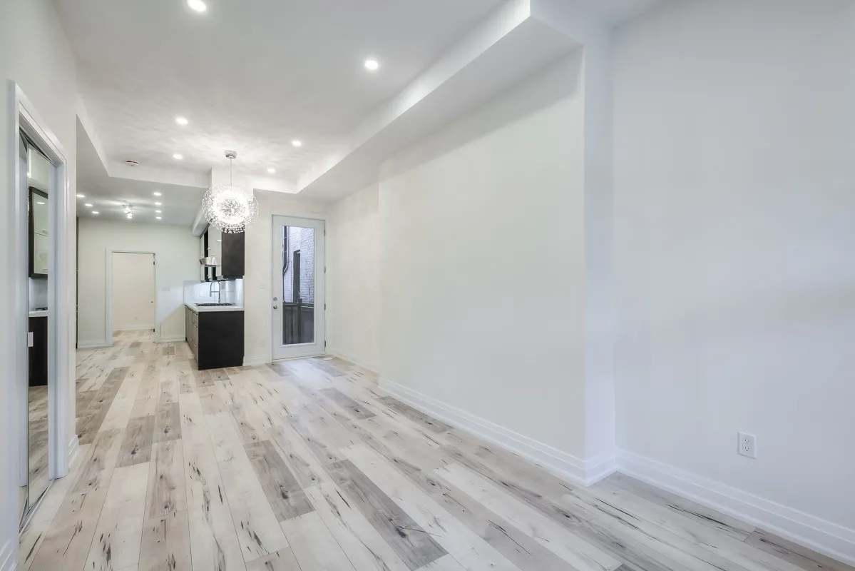 A room with a white wall and wood floor