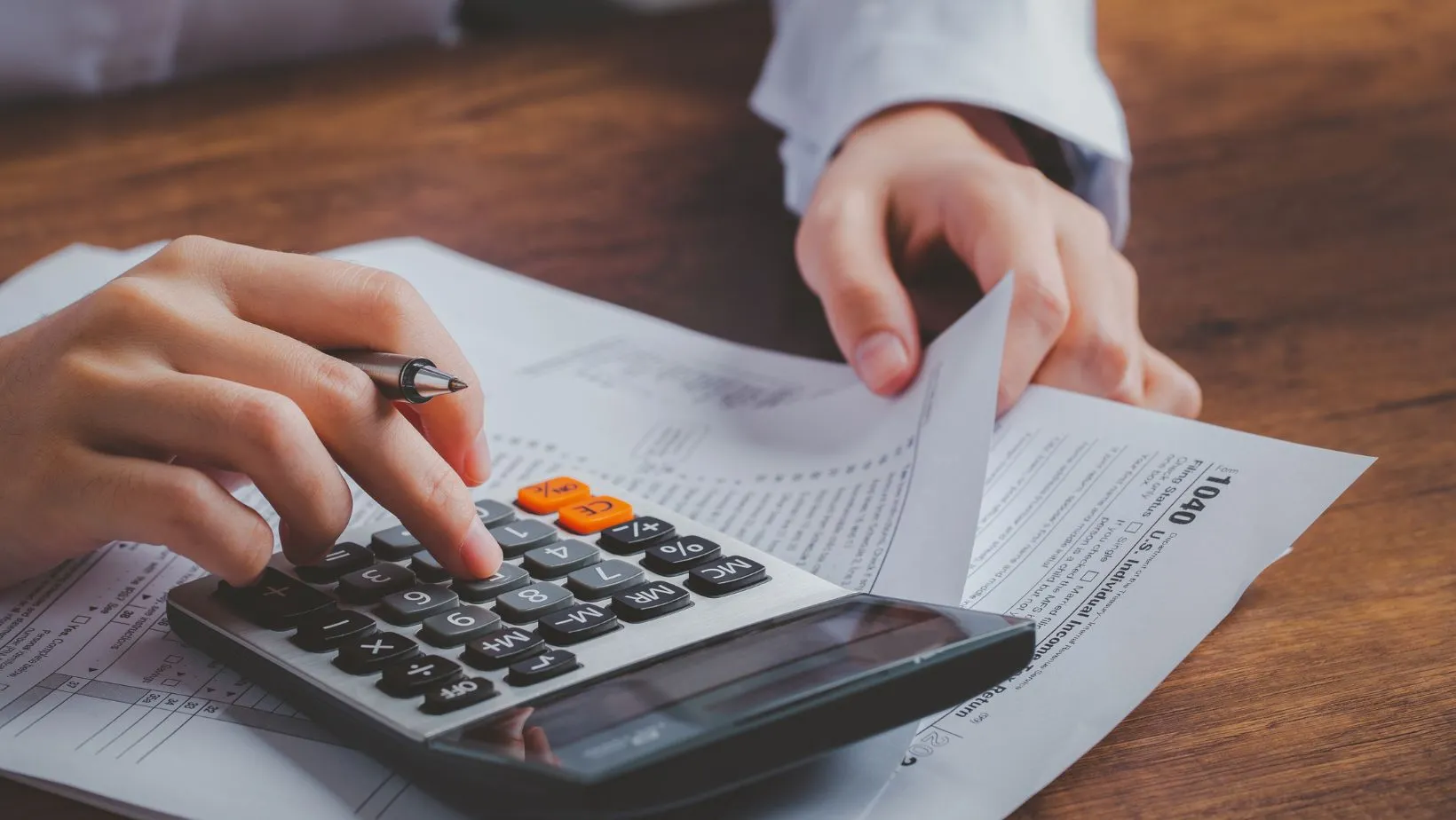 A person using a calculator and a pen