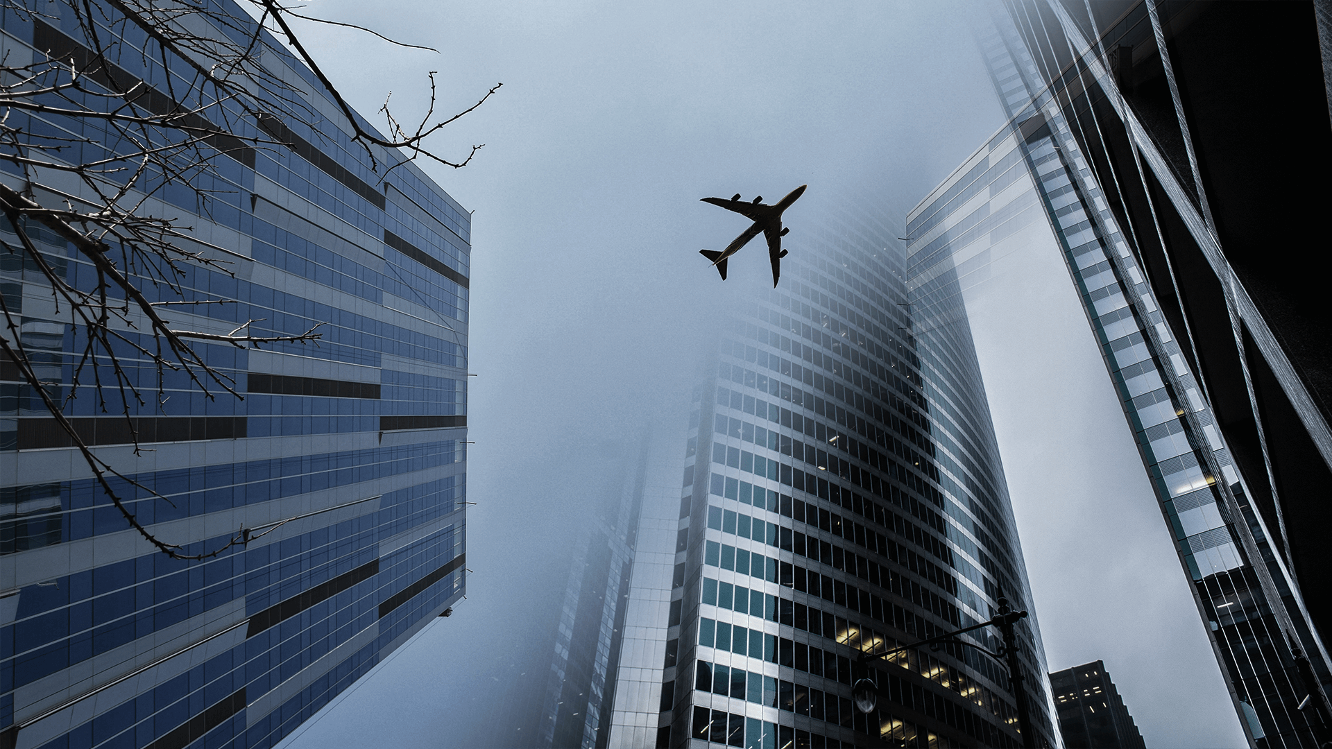 A tall building with many windows and an airplane in the sky