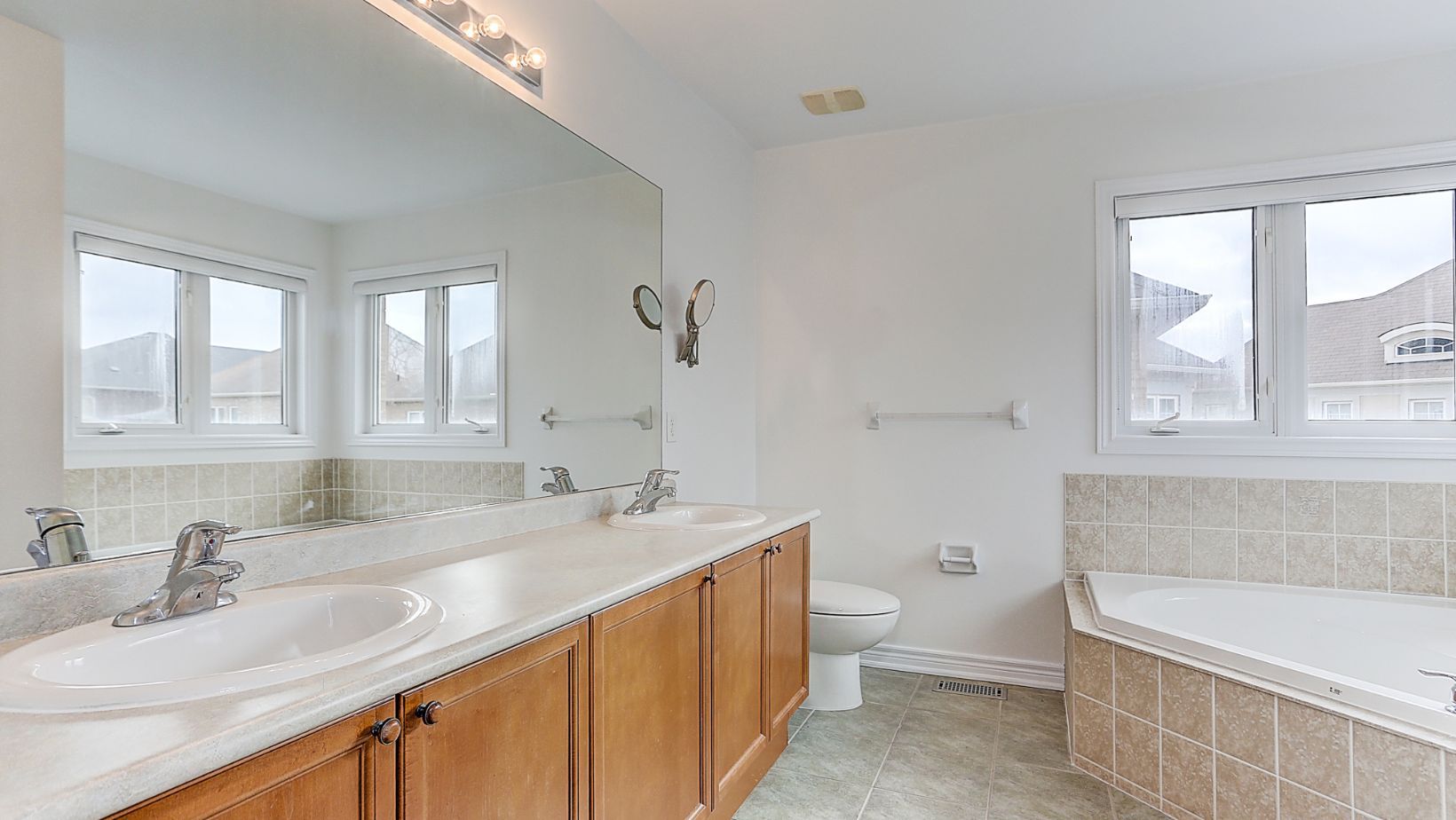 A spacious bathroom of a house, with a bathtub on tiles