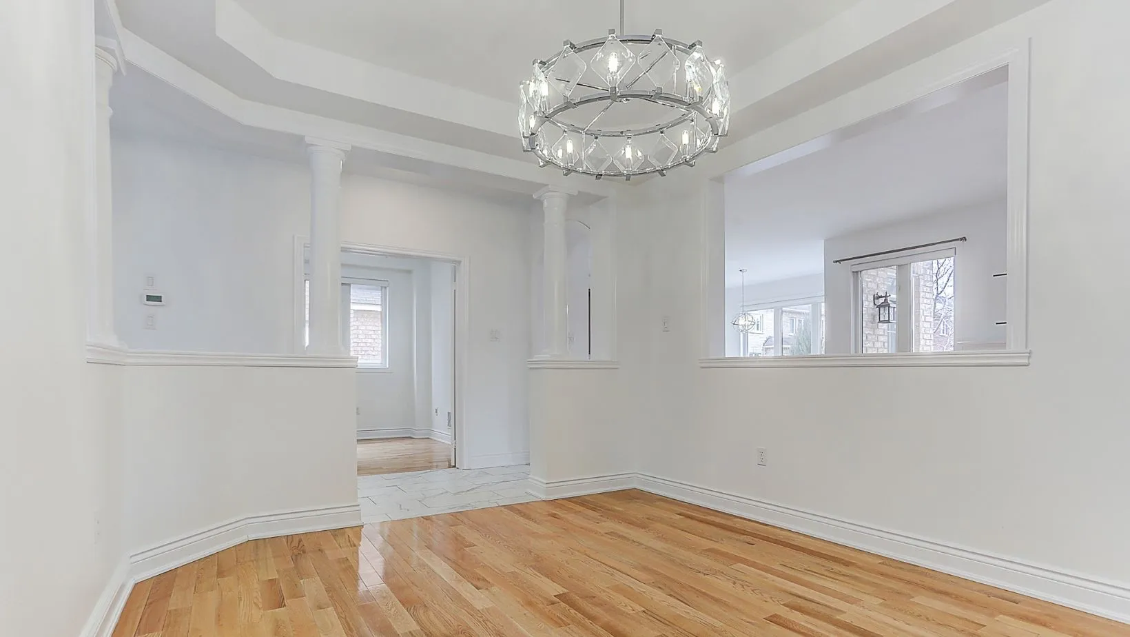 A single-family home living room, all white, with a light fixture