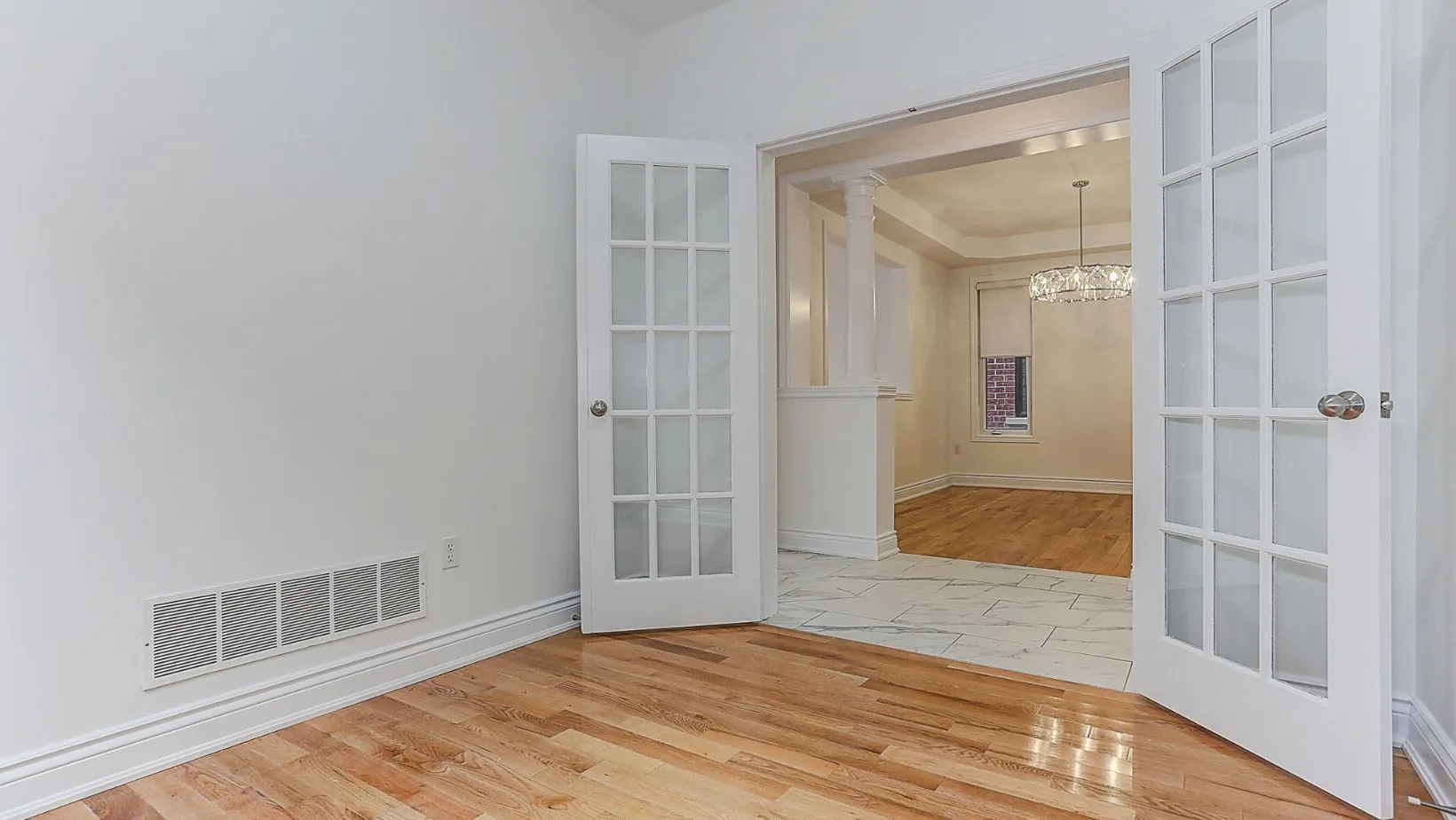 A white living space of a house with wood floor