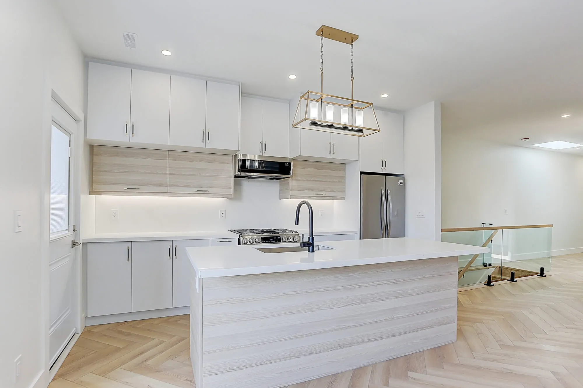 A newly designed kitchen with modern appliances and light fixtures