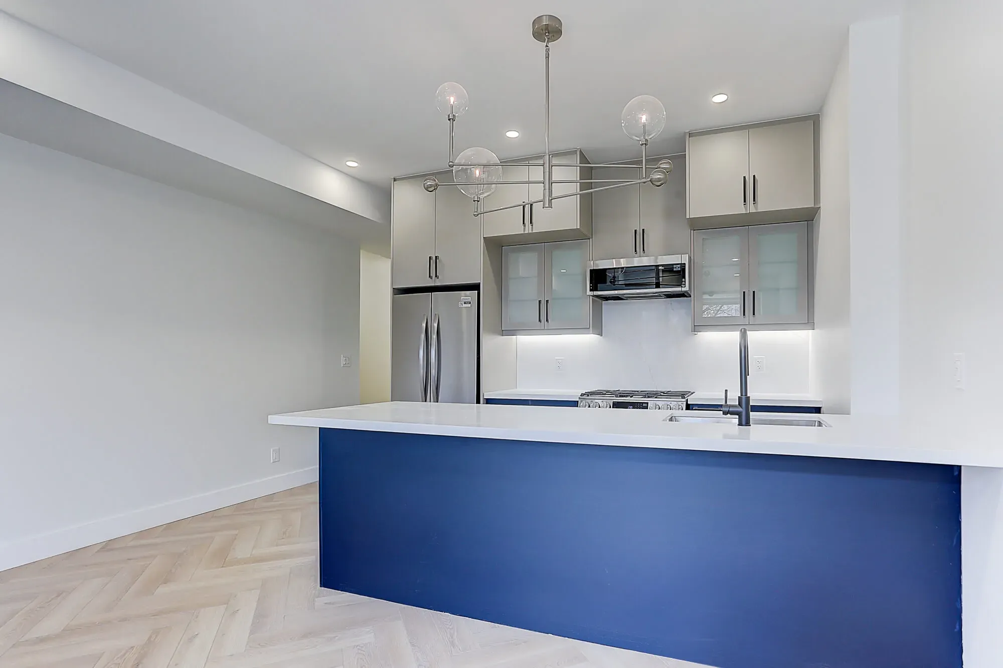 A newly designed kitchen with modern appliances and light fixtures