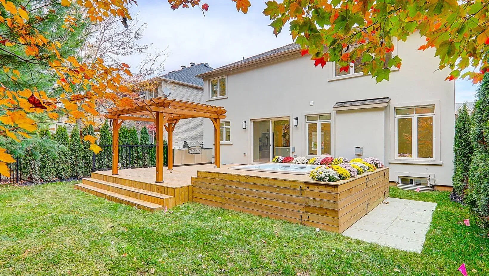 A rental property with a hot tub and a wooden deck